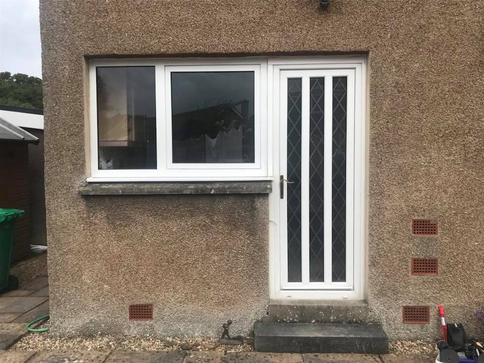White uPVC fixed frame with Cotswold toughened, white outer frame and anthracite grey on white Lyon 6 panel in the door.